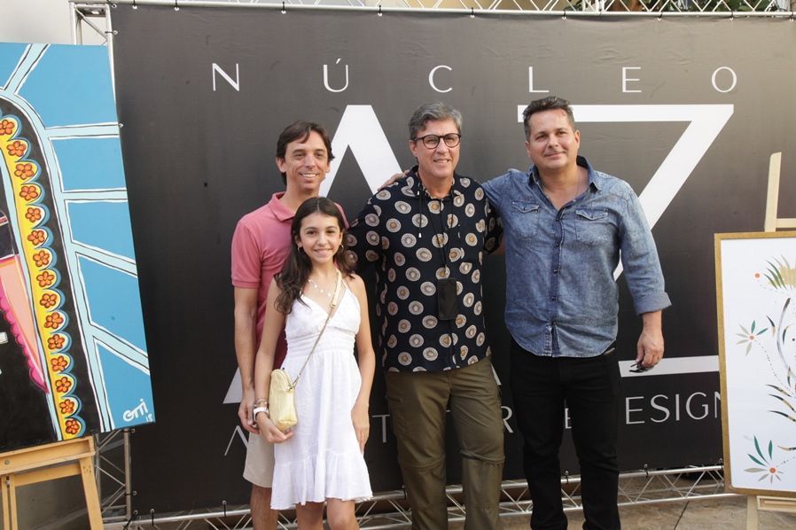 Um grupo de pessoas em pé em frente a uma placa que diz nucleo