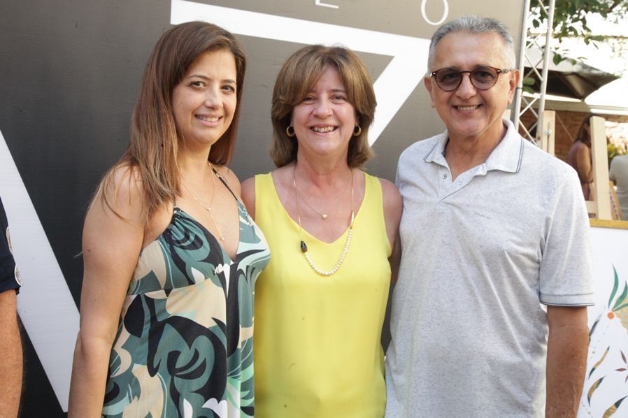 Um homem e duas mulheres estão posando para uma foto juntos