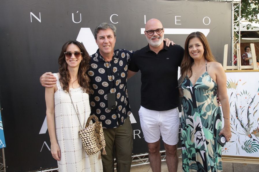Um grupo de pessoas posando para uma foto em frente a uma placa que diz nucleo