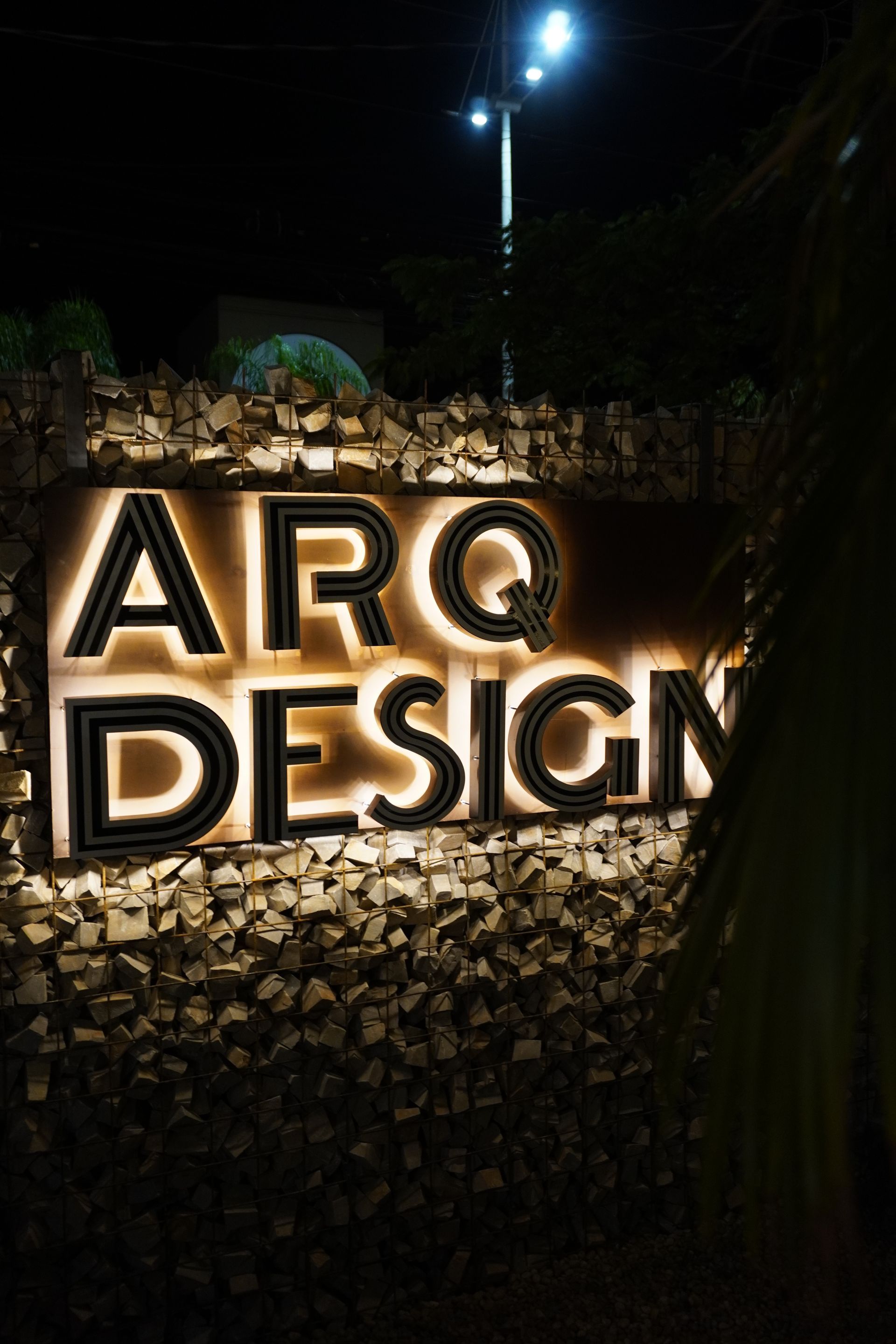 Uma placa para arq design é iluminada à noite