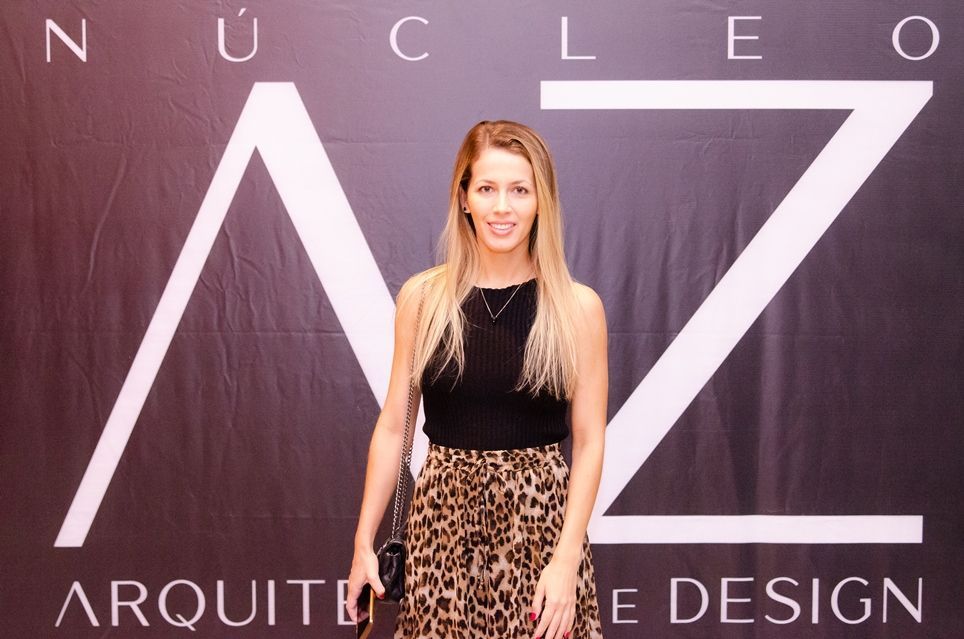 Uma mulher com uma saia estampada de leopardo está em frente a uma placa que diz nucleo