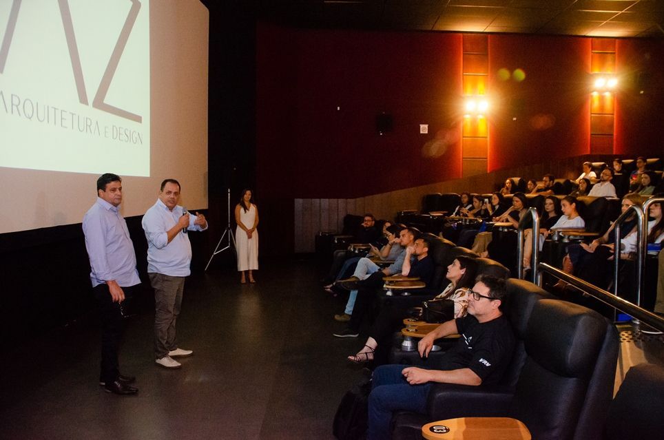 Um grupo de pessoas está sentado em um cinema assistindo a um filme.