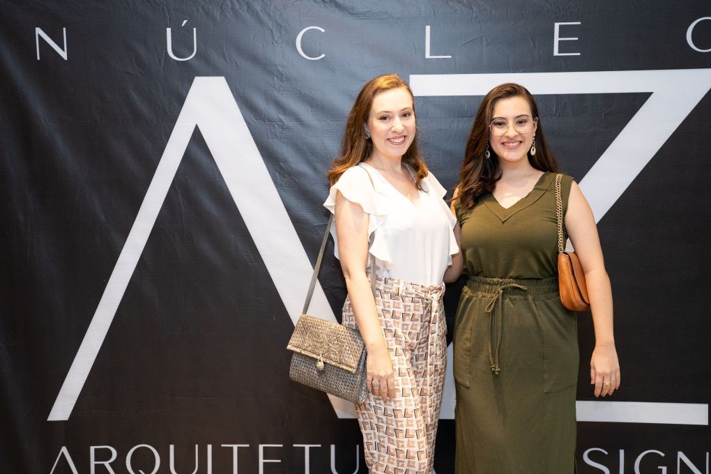 Duas mulheres estão posando para uma foto em frente a uma placa que diz nuclear
