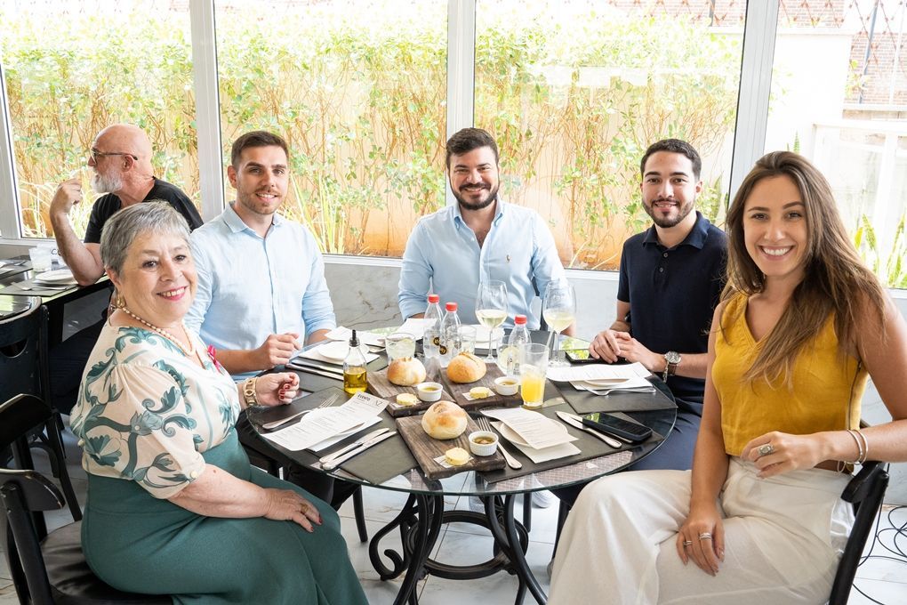Um grupo de pessoas está sentado ao redor de uma mesa em um restaurante.