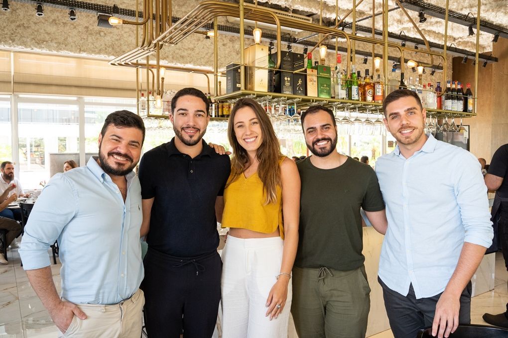 Um grupo de pessoas está posando para uma foto em um restaurante.