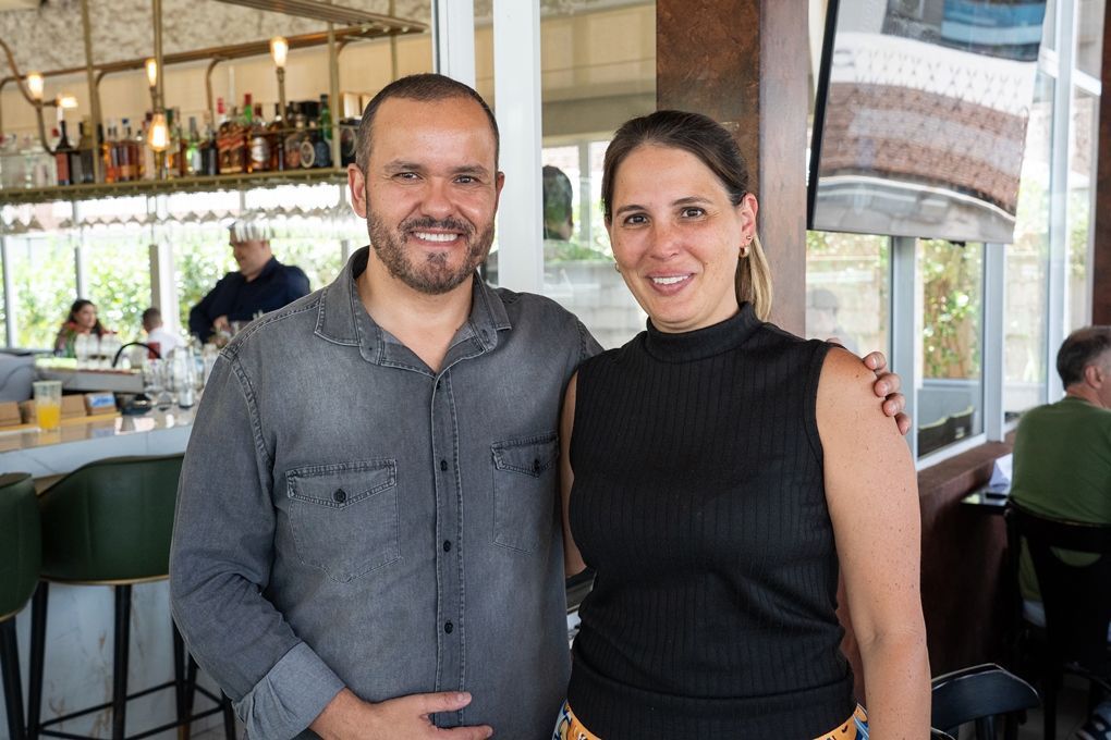 Um homem e uma mulher estão posando para uma foto em um restaurante.