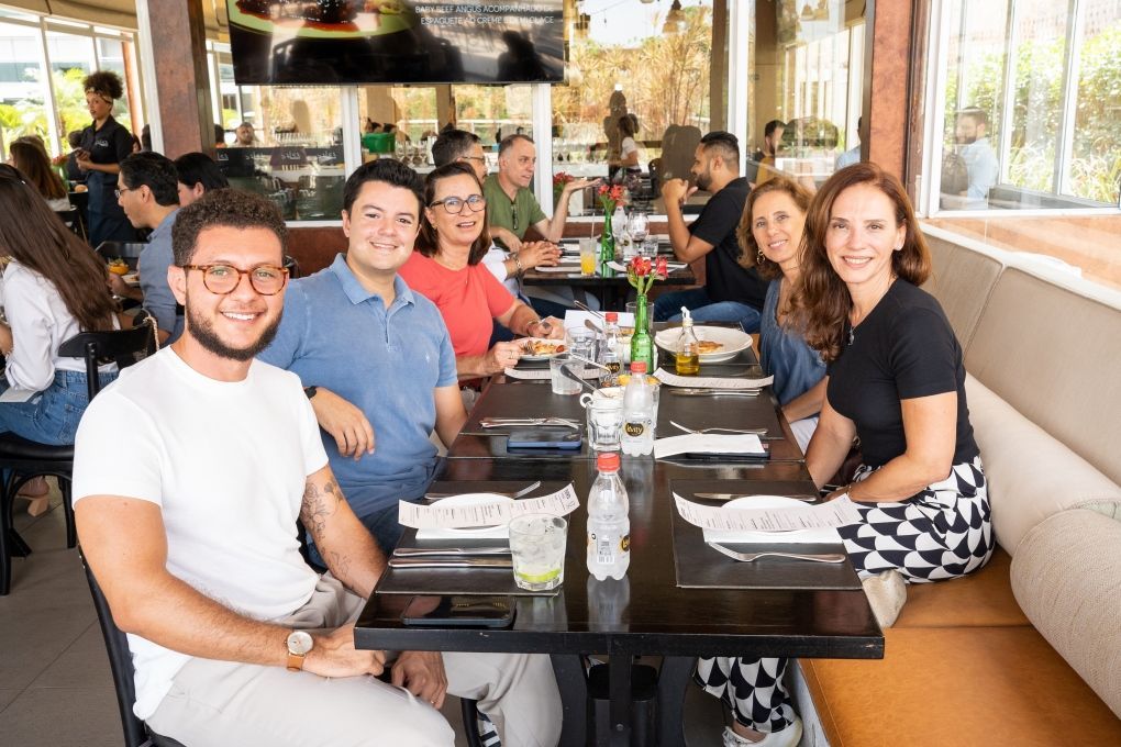 Um grupo de pessoas está sentado à mesa em um restaurante.