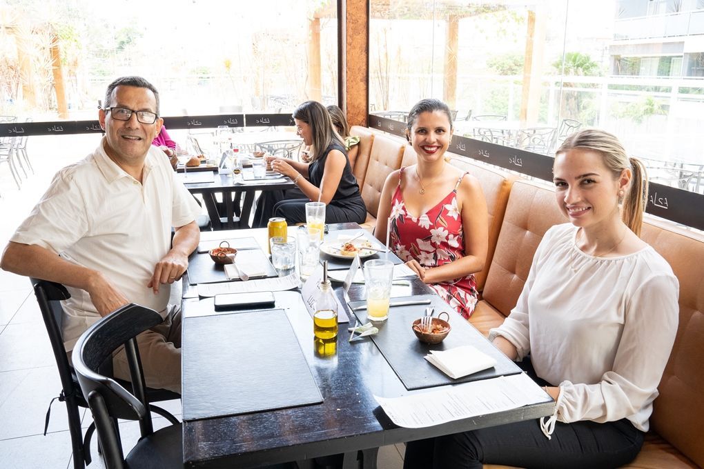Um grupo de pessoas está sentado à mesa em um restaurante.