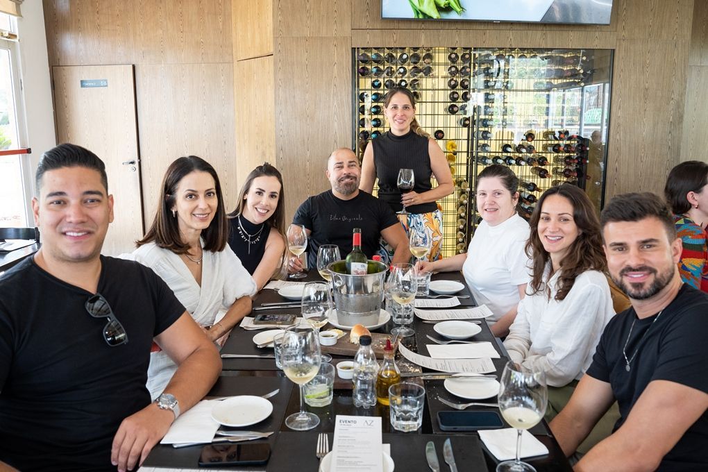 Um grupo de pessoas está sentado à mesa em um restaurante.