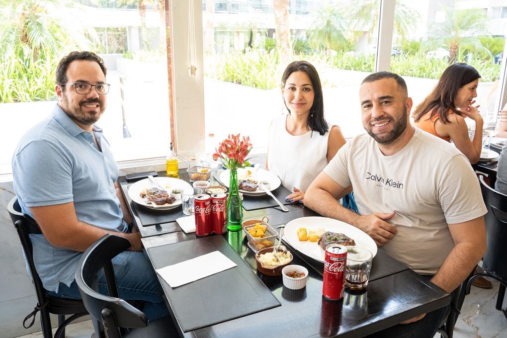 Um grupo de pessoas está sentado à mesa de um restaurante comendo.