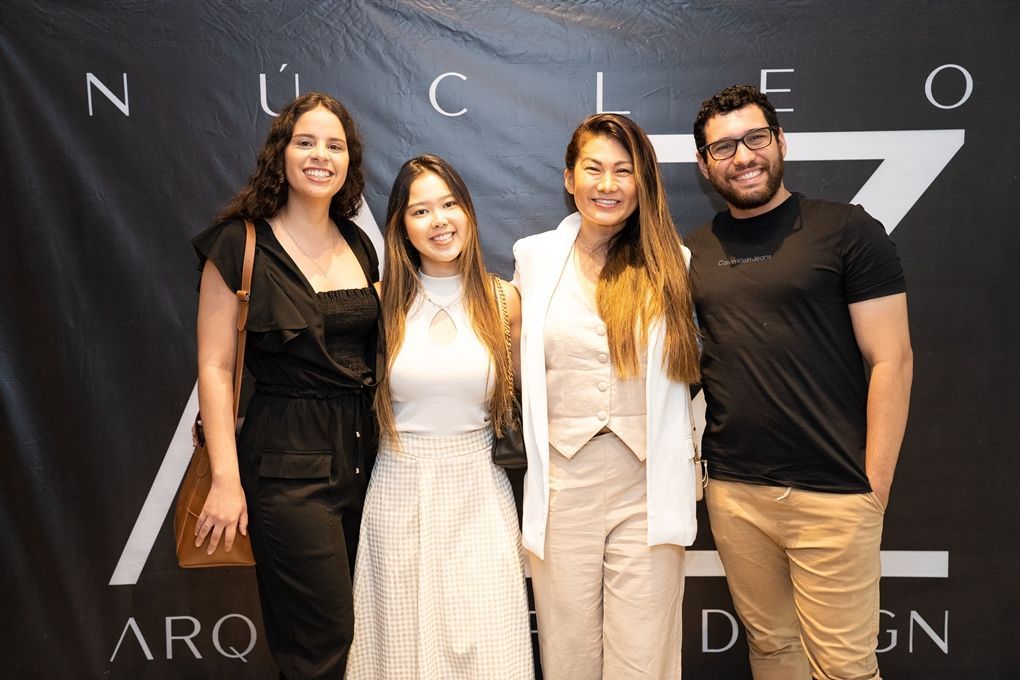 Um grupo de pessoas está posando para uma foto em frente a uma placa que diz nucleo