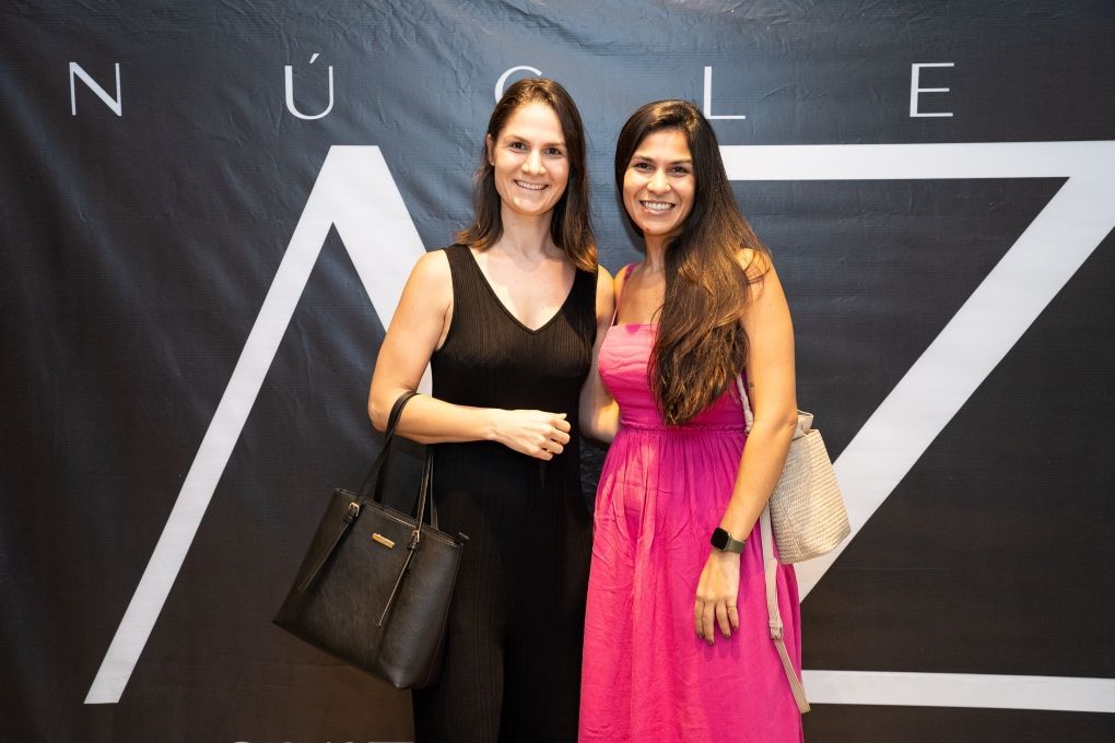 Duas mulheres estão posando para uma foto em frente a uma placa que diz nuclear