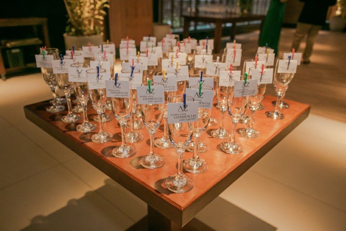 Uma mesa de madeira coberta com muitas taças de champanhe.