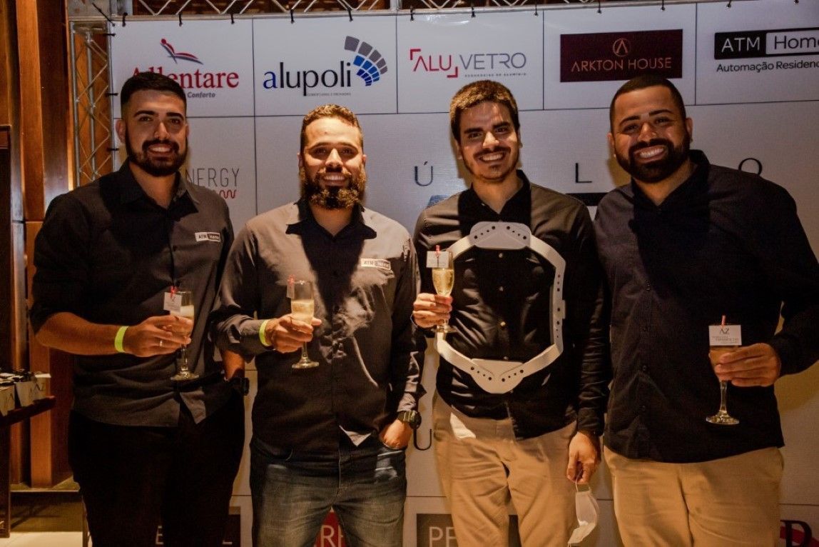 Um grupo de homens de pé um ao lado do outro segurando taças de champanhe