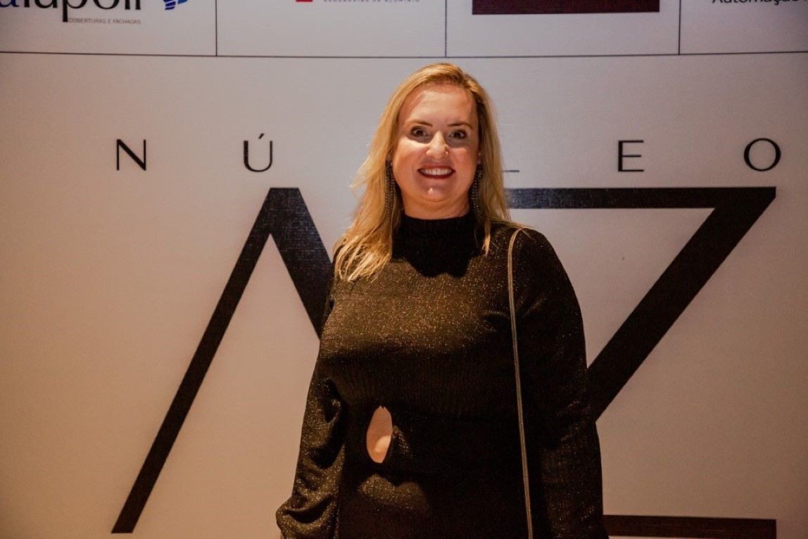Uma mulher está parada em frente a uma placa que diz nuevo