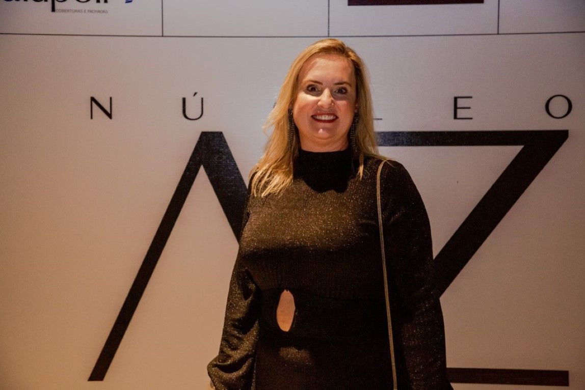 Uma mulher está parada em frente a uma placa que diz nueo