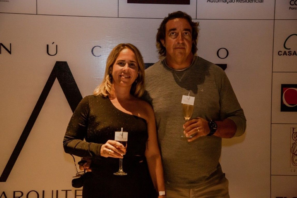 Um homem e uma mulher de pé um ao lado do outro segurando taças de champanhe