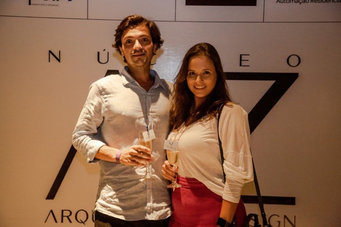 Um homem e uma mulher estão de pé, um ao lado do outro, segurando taças de champanhe.