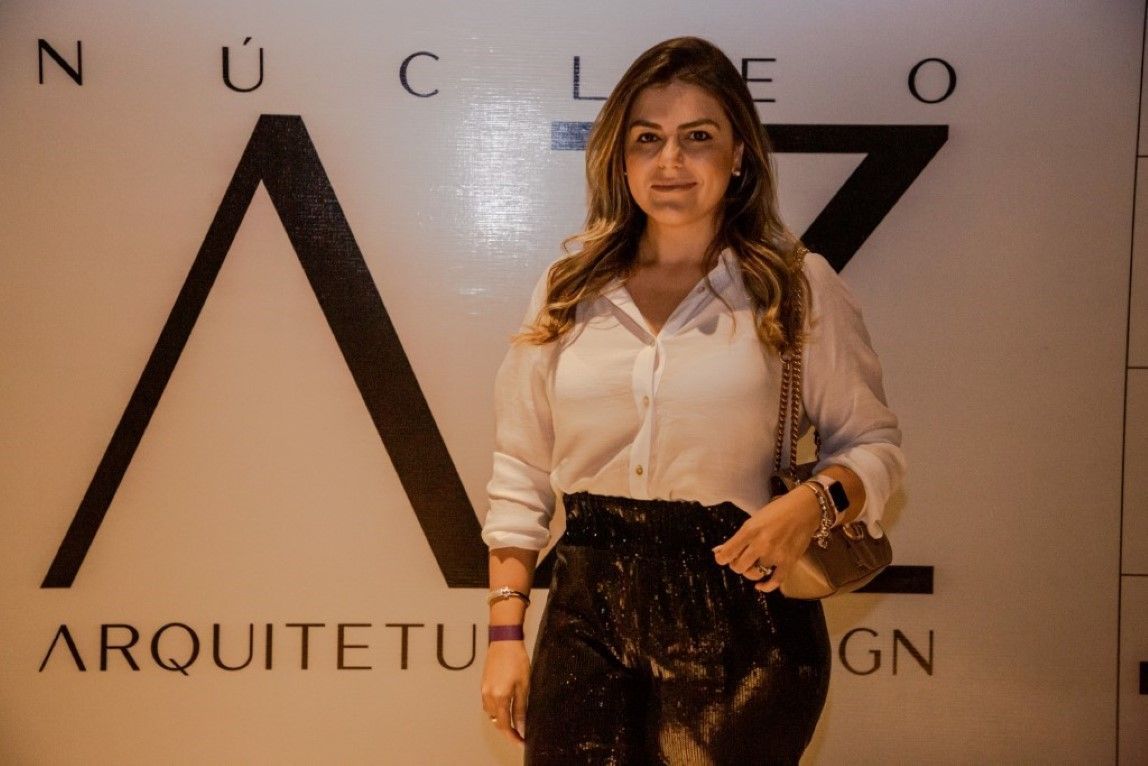Uma mulher parada em frente a uma placa que diz arquitetu
