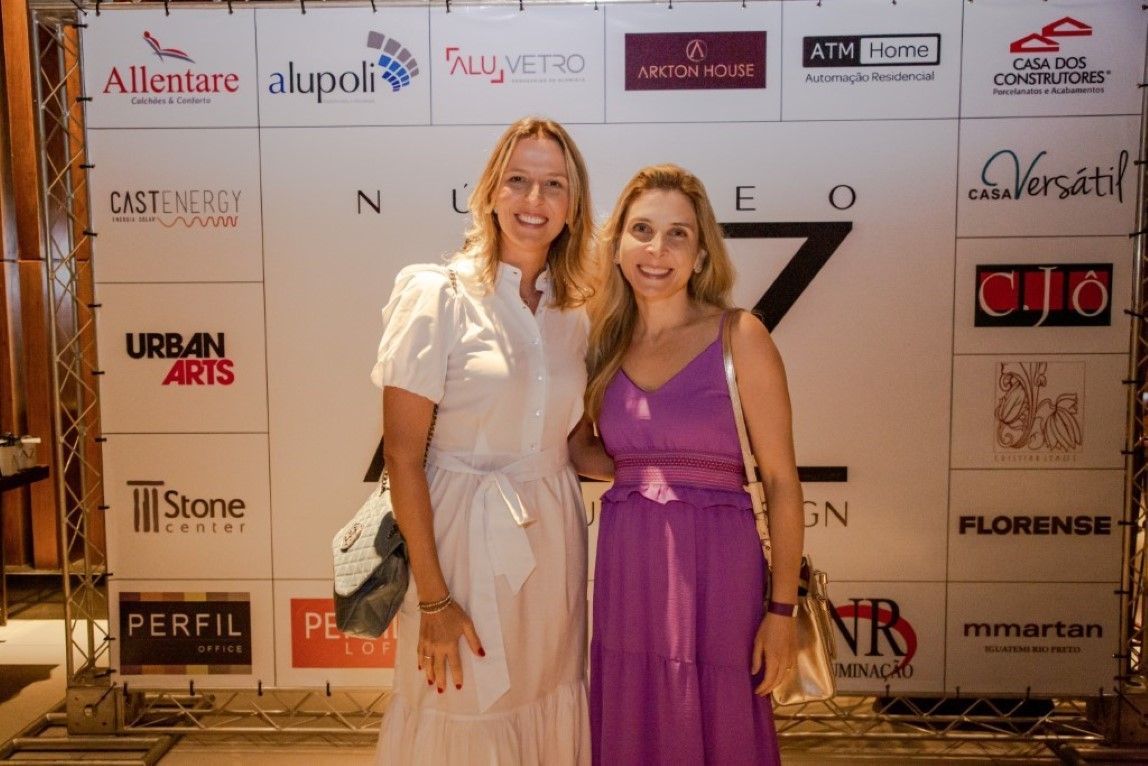 Duas mulheres posam para uma foto em frente a uma placa que diz artes urbanas