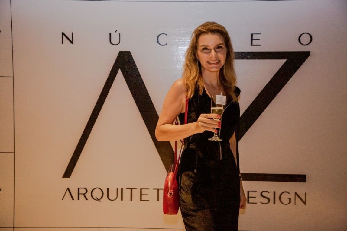 Uma mulher está parada em frente a uma placa que diz arquiteto design