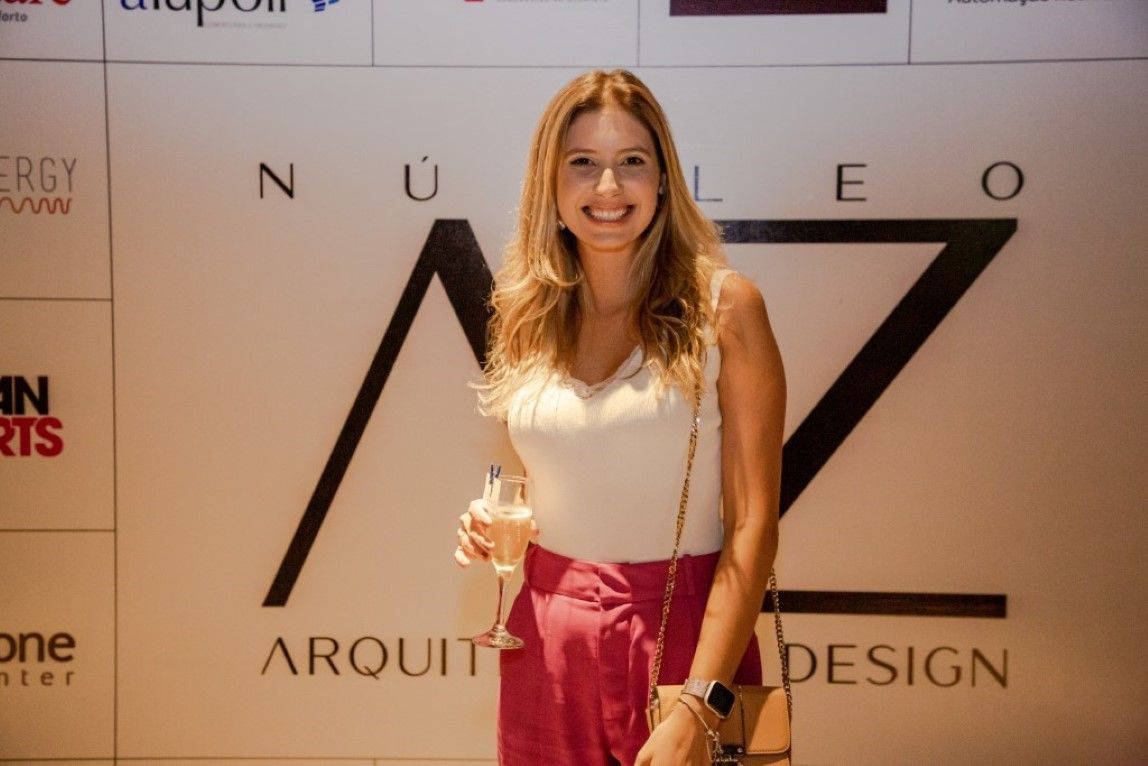 Uma mulher está parada em frente a uma parede com a letra z nela