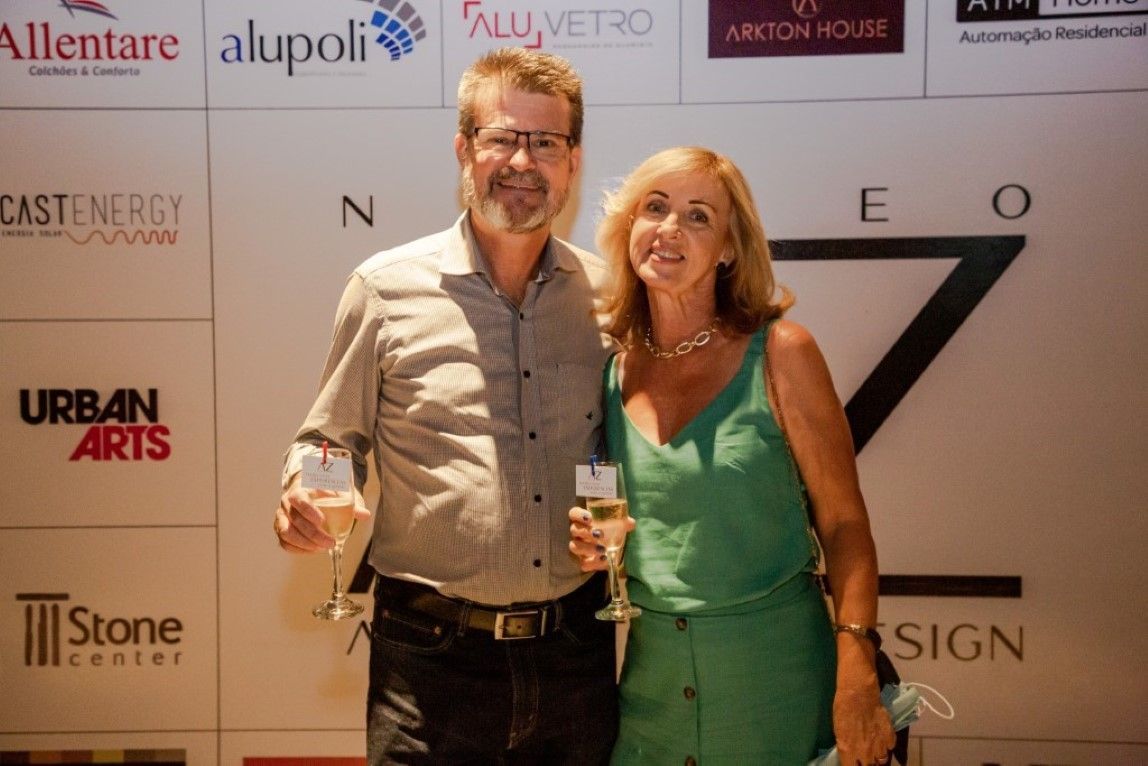 Um homem e uma mulher estão posando para uma foto segurando taças de vinho.