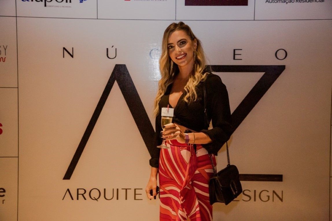 Uma mulher está parada em frente a uma placa que diz arquitet design