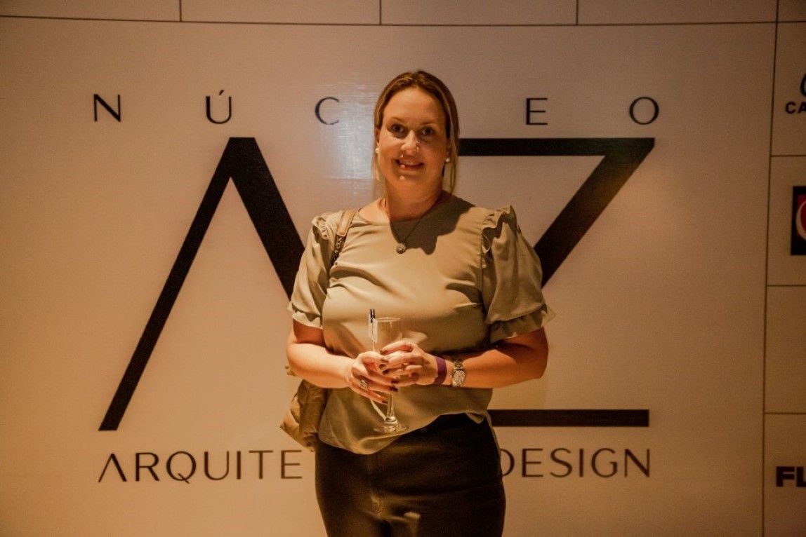 Uma mulher está parada em frente a uma placa que diz arquitet design