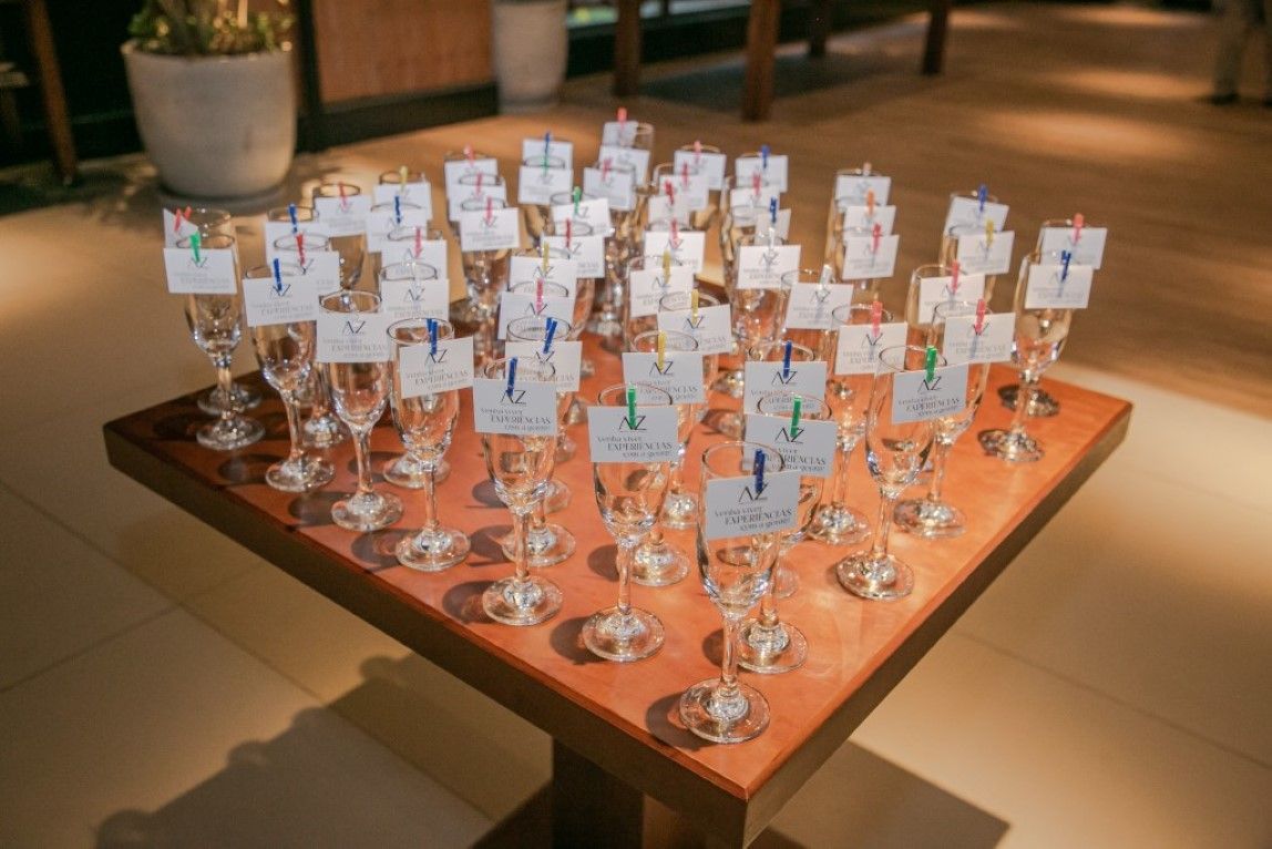 Uma mesa coberta com muitas taças de vinho e crachás.