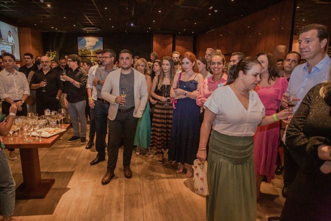 Um grande grupo de pessoas está em pé em uma sala.