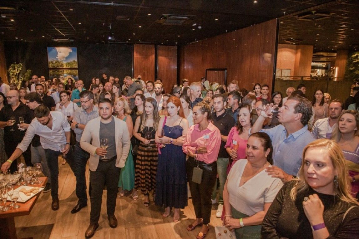 Um grande grupo de pessoas está em pé em uma sala.