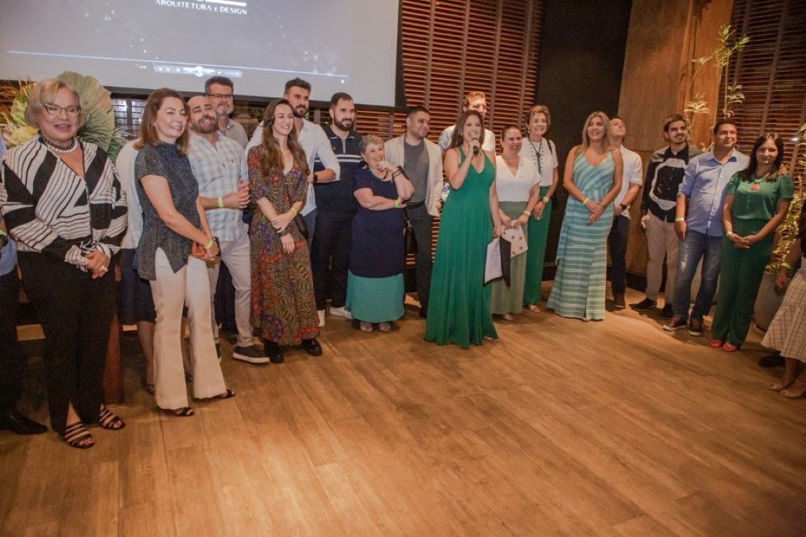 Um grupo de pessoas está de pé sobre um piso de madeira em uma sala.