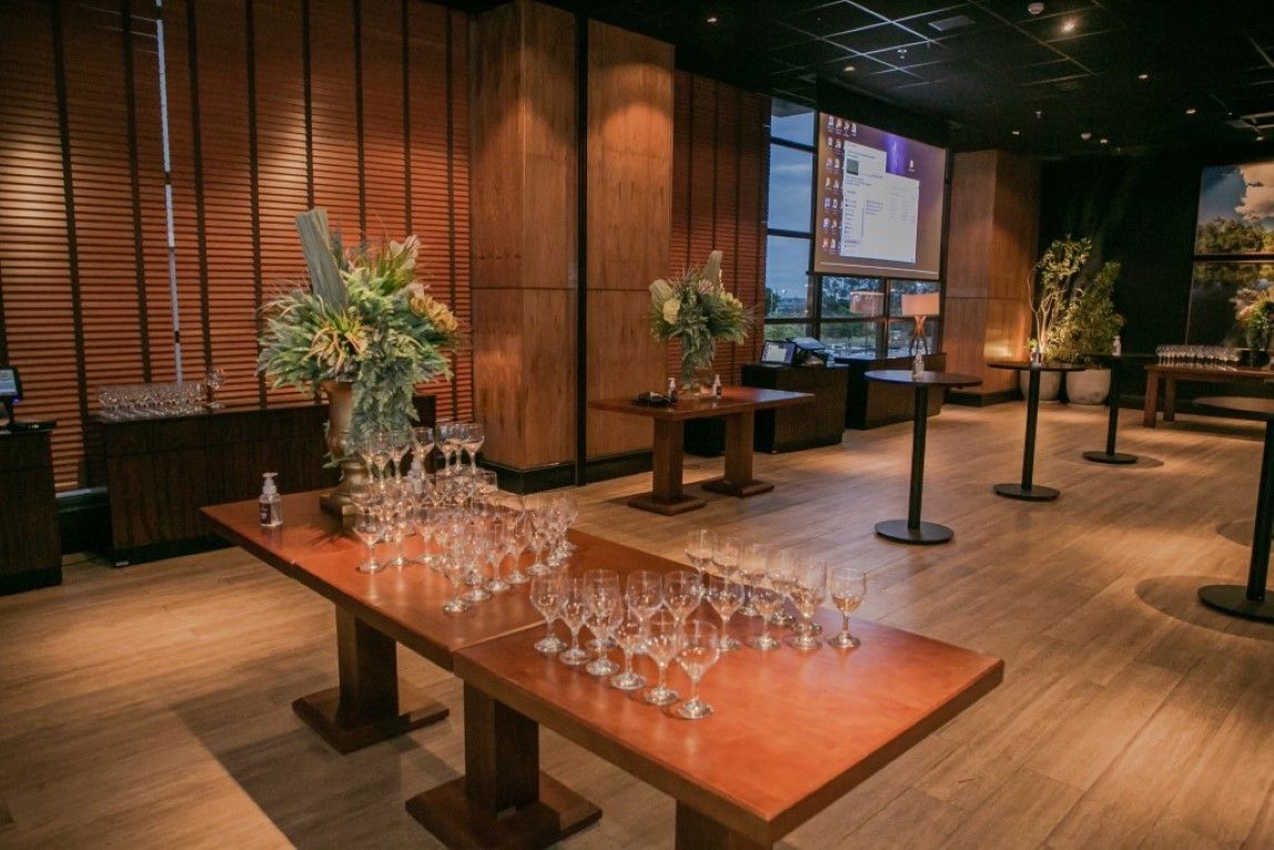 Uma mesa de madeira com taças de vinho em cima dela em uma sala.
