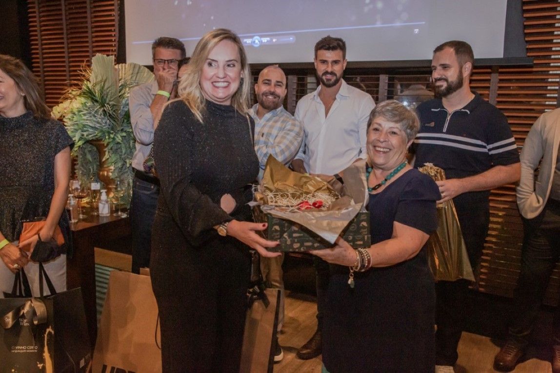 Uma mulher está dando um presente para outra mulher em uma festa.