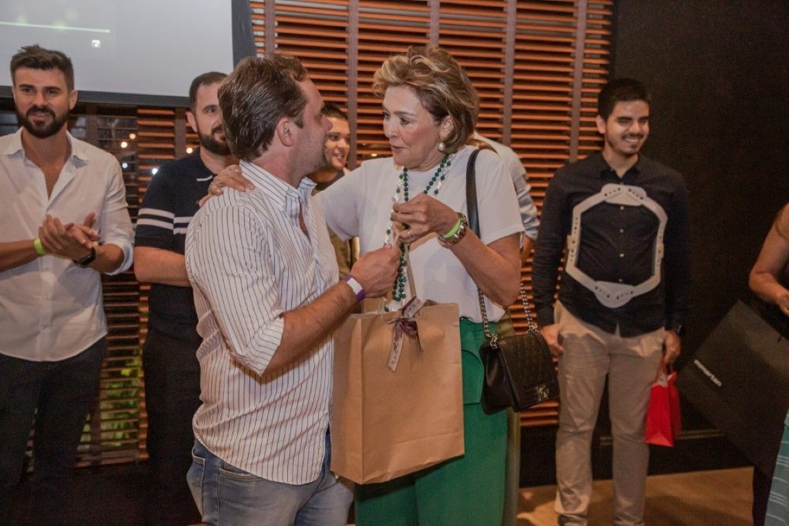 Um grupo de pessoas está em volta de um homem e uma mulher.