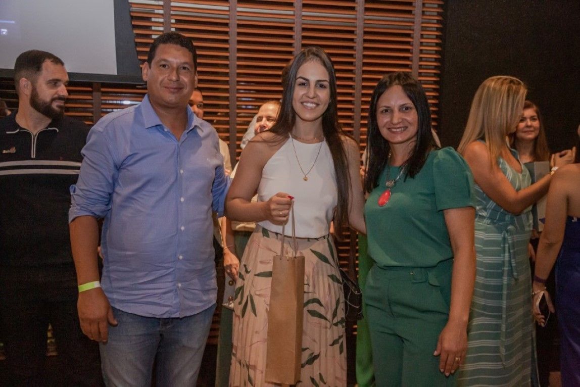 Um grupo de pessoas está posando para uma foto em uma sala.