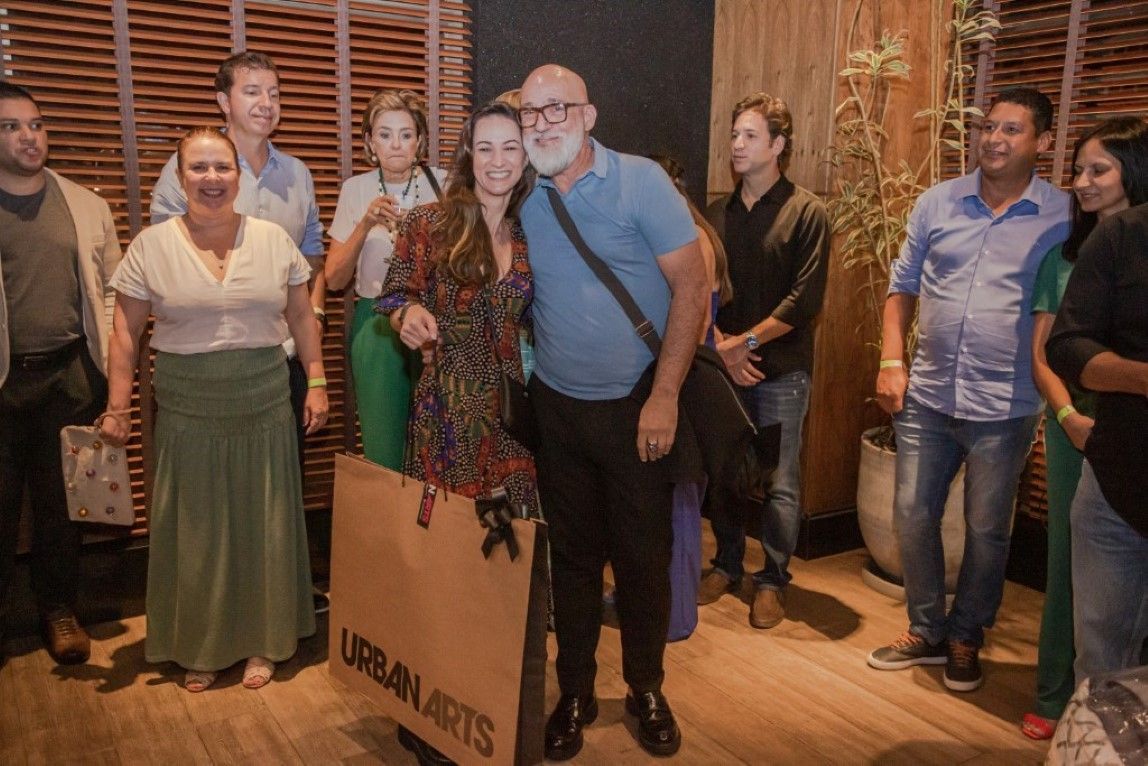Um grupo de pessoas está posando para uma foto em uma sala.