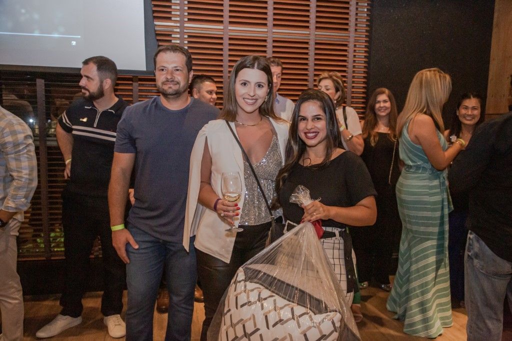 Um grupo de pessoas está posando para uma foto em uma sala.