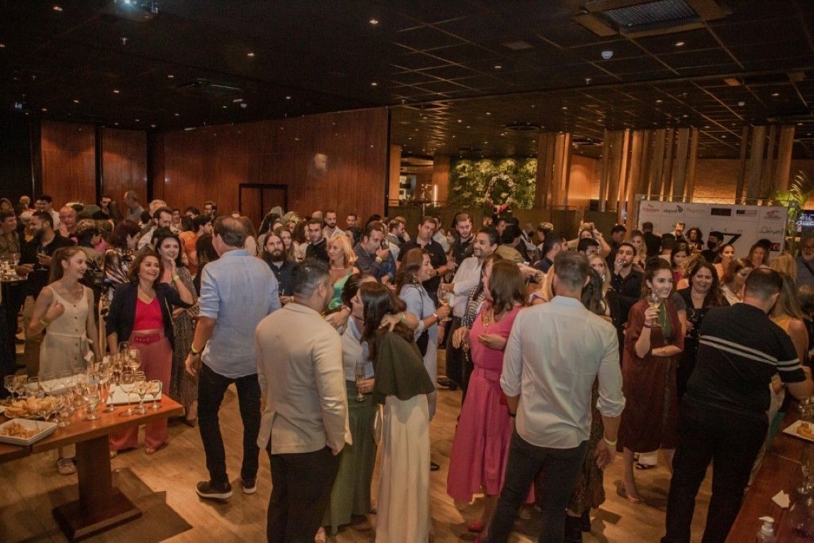 Um grande grupo de pessoas está dançando em uma sala grande.