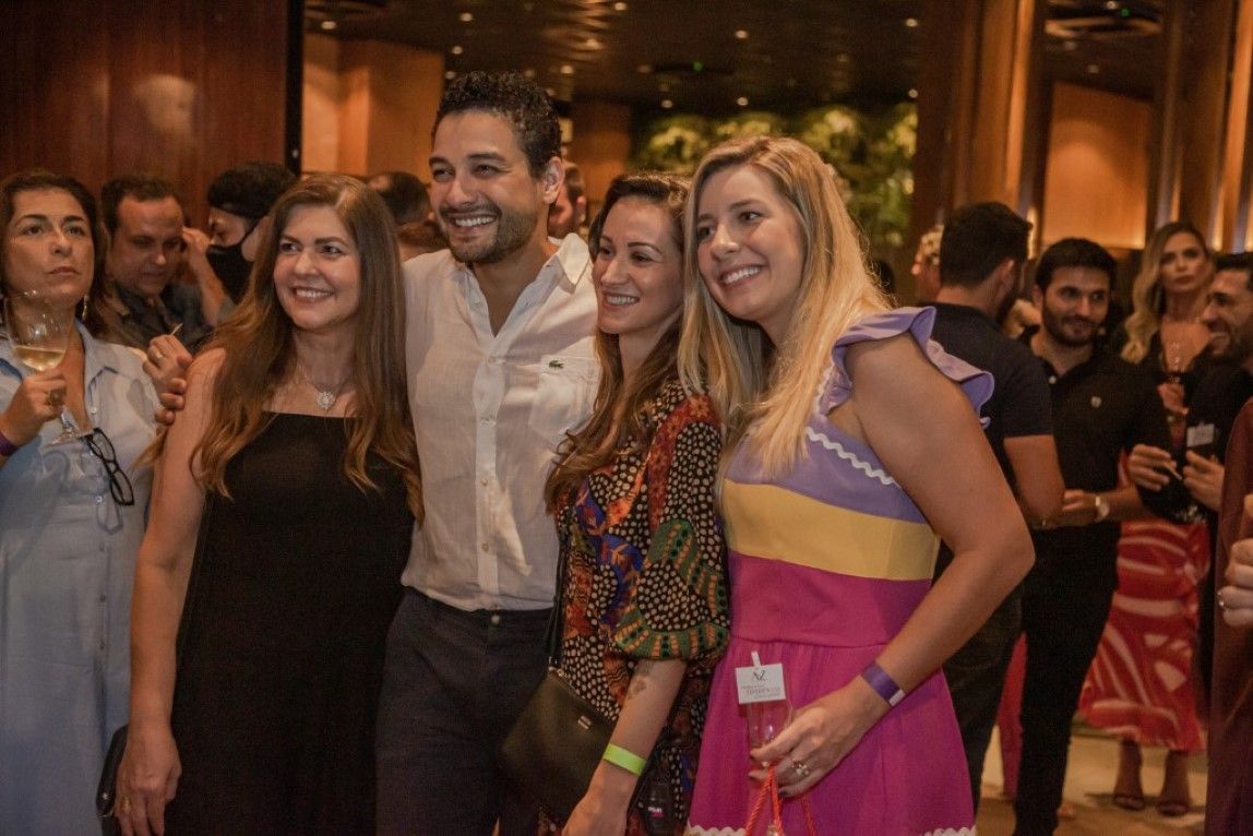 Um grupo de pessoas está posando para uma foto em uma festa.