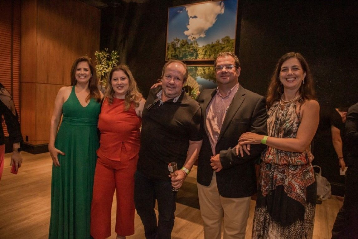 Um grupo de pessoas está posando para uma foto juntas em uma sala.