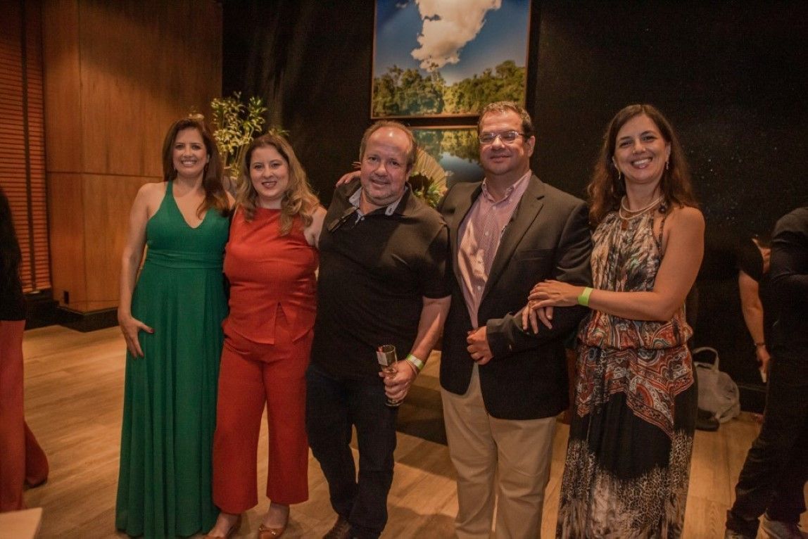 Um grupo de pessoas está posando para uma foto juntas em uma sala.