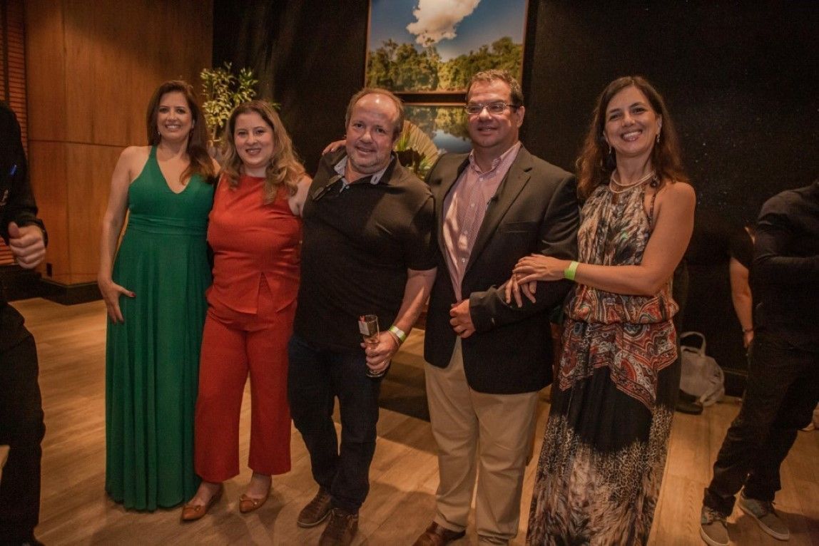 Um grupo de pessoas está posando para uma foto juntas em uma sala.
