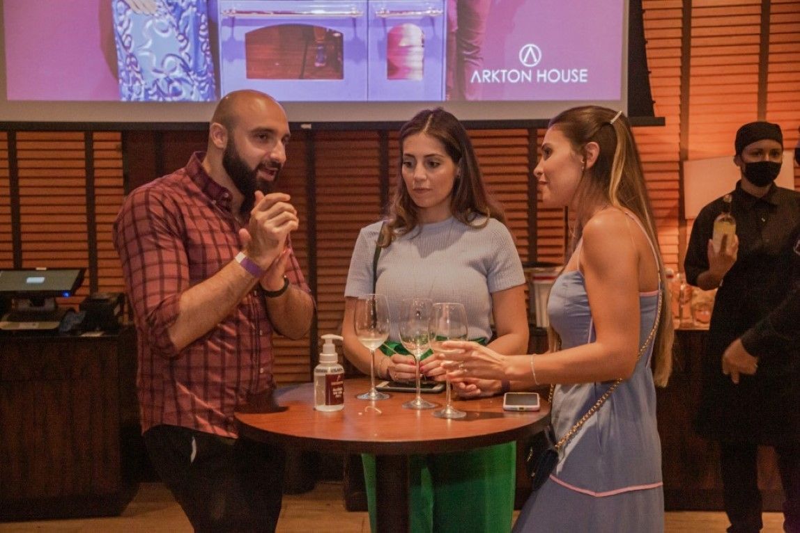 Um grupo de pessoas está em volta de uma mesa conversando entre si.
