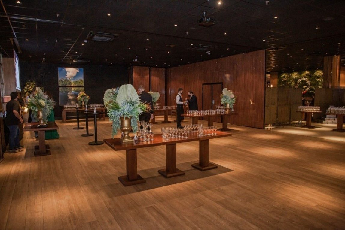 Uma grande sala cheia de mesas de madeira e copos.