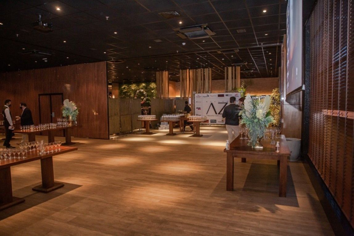 Uma sala grande com mesas de madeira e uma tela de projetor.