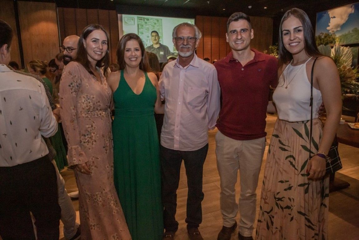 Um grupo de pessoas está posando para uma foto juntas em uma sala.