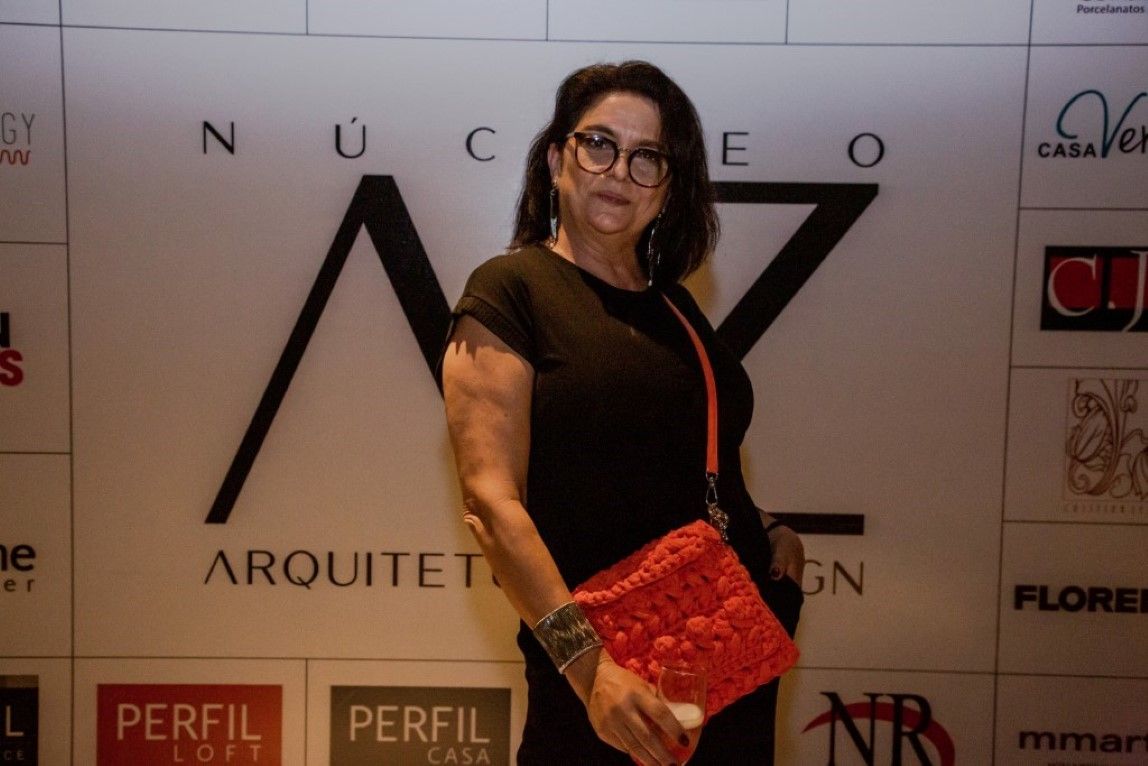 Uma mulher parada em frente a uma parede que diz perfil