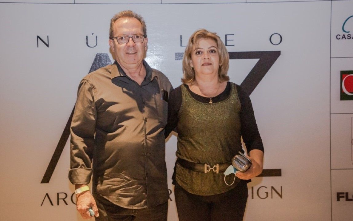 Um homem e uma mulher estão posando para uma foto em frente a uma parede que tem a letra z nela